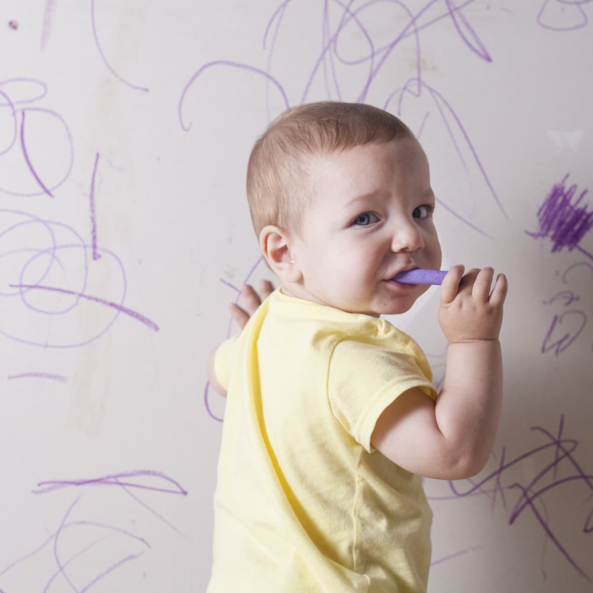 A baby with purple crayon